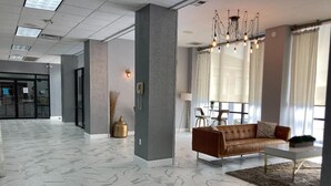 A modern lobby with a marble floor, a leather sofa, and a chandelier. - Wyndham Garden Lake Guntersville (Guntersville)