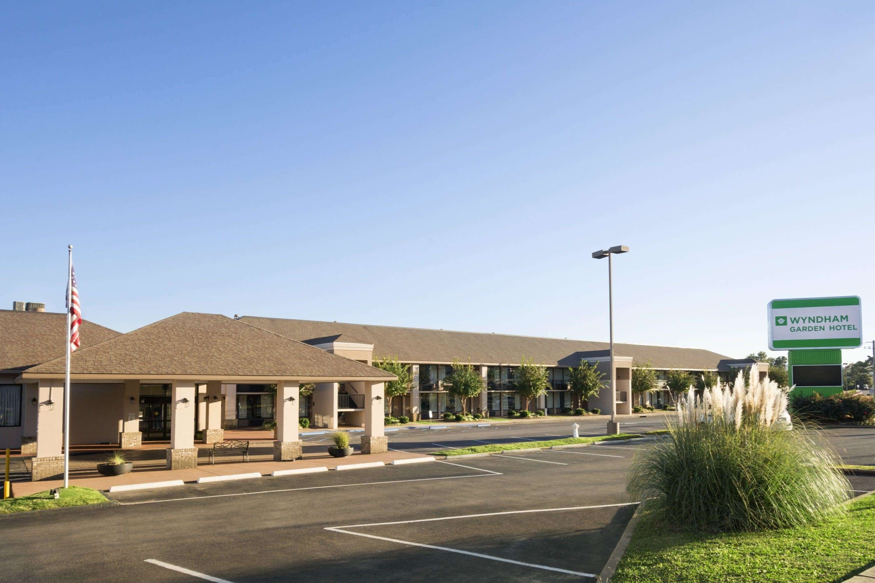 A Wyndham Garden Hotel with a parking lot, a covered entrance, and a signboard.