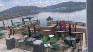 A lakeside patio with outdoor seating and a playground. - Wyndham Garden Lake Guntersville (Guntersville)