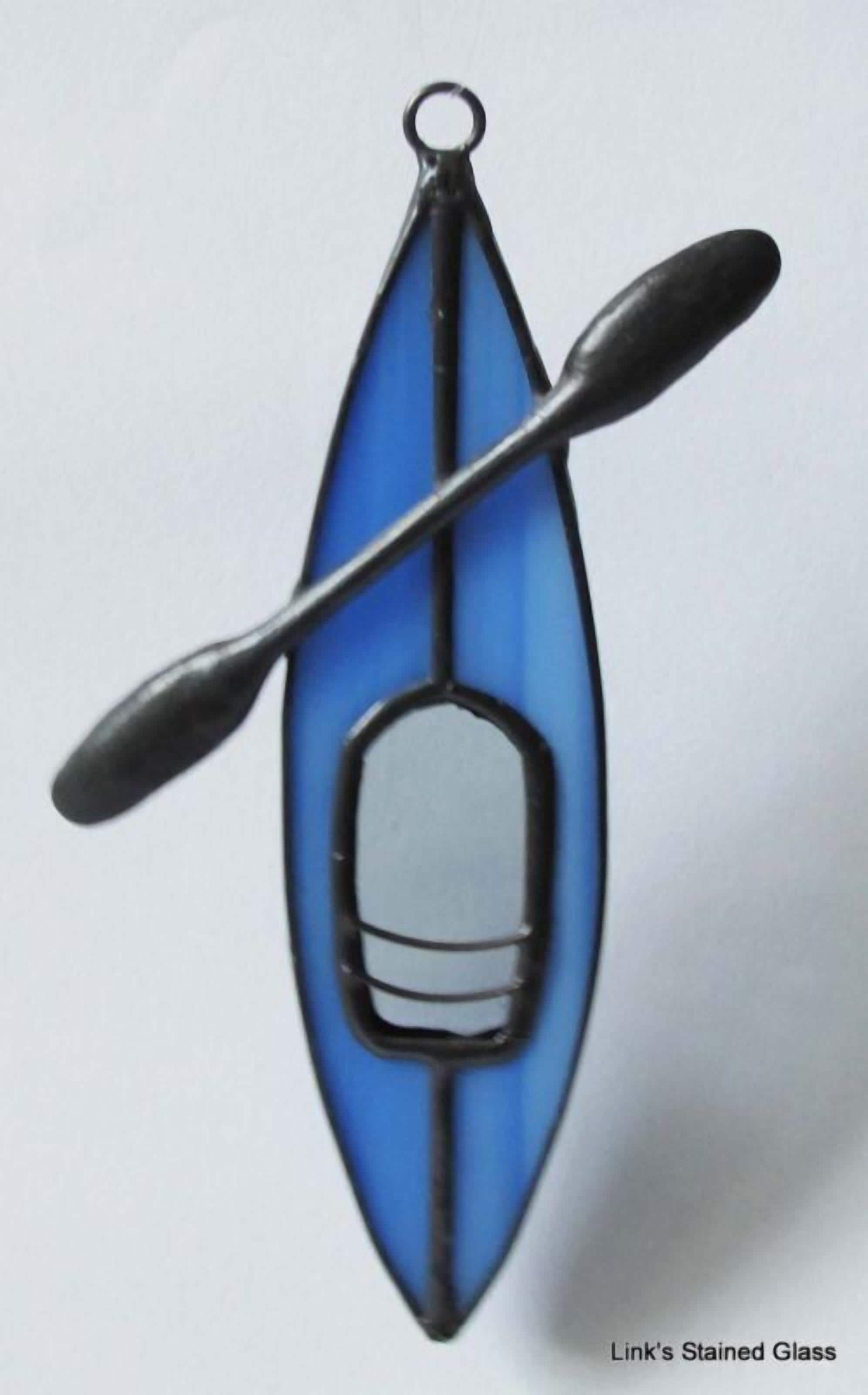 A blue kayak with a paddle and a small storage container.