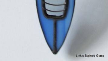 A blue kayak with a paddle and a small storage container.