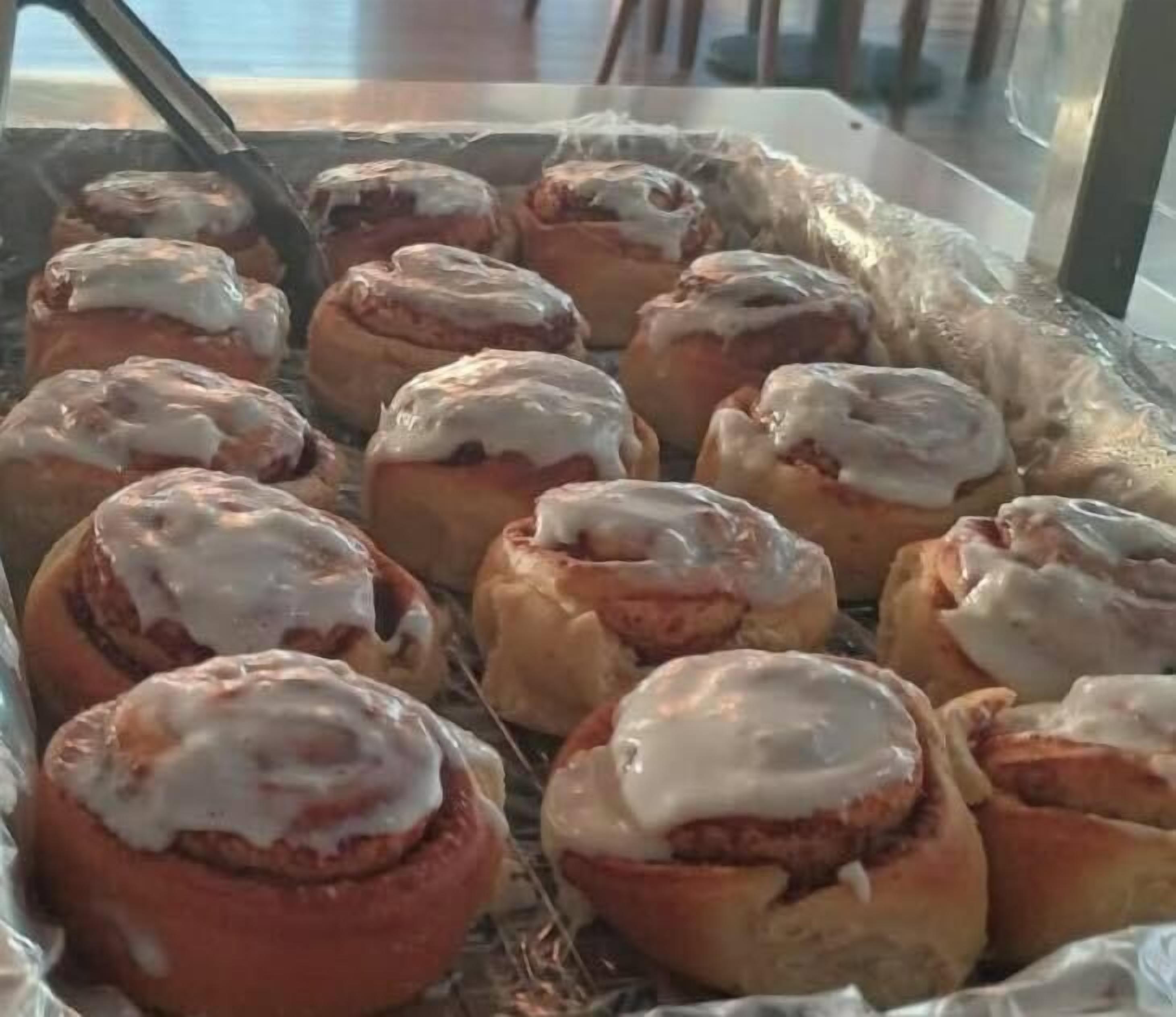 A tray of cinnamon rolls with icing.