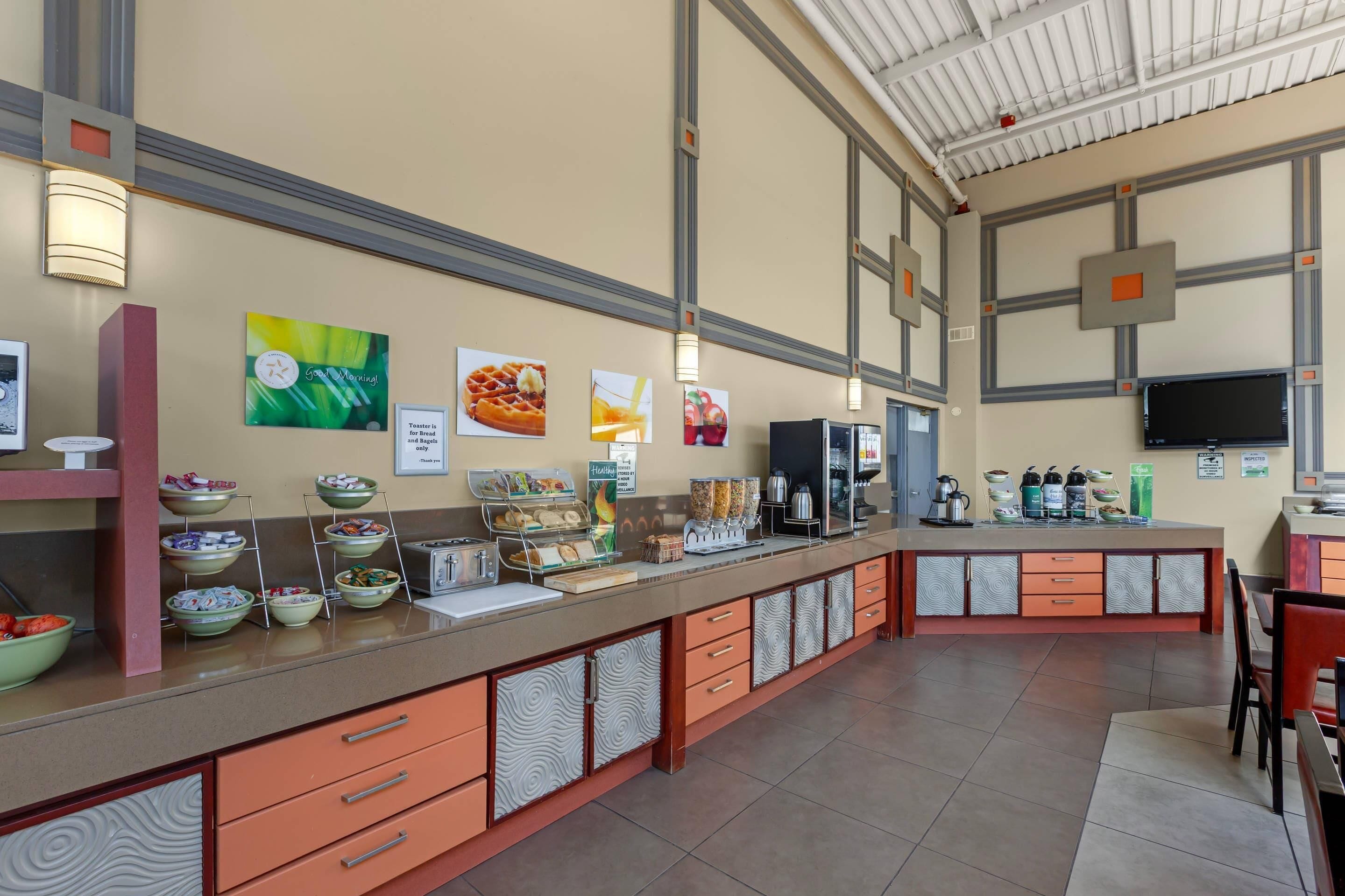 A breakfast bar with various food items and a toaster.