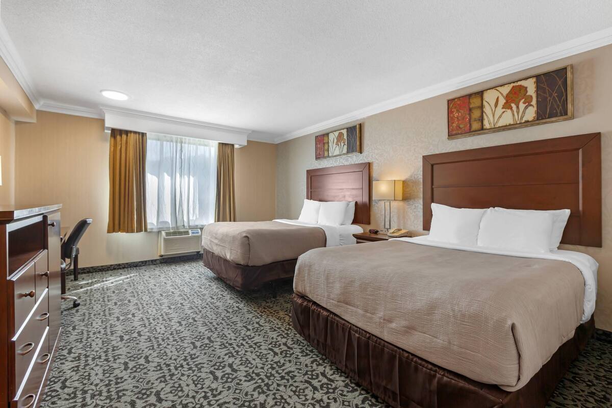 Una habitación de hotel con dos camas, un escritorio y una silla.