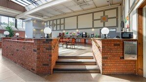 A spacious kitchen with a brick island, modern appliances, and a large window providing natural light. - Quality Inn & Conference Centre (Midland)