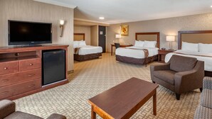 A hotel room with two beds, a TV, a desk, and a chair. - Quality Inn & Conference Centre (Midland)