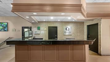 A hotel reception desk with a sign indicating 'Quality by Choice Hotels.'