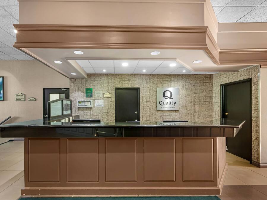 A hotel reception desk with a sign indicating 'Quality by Choice Hotels.'