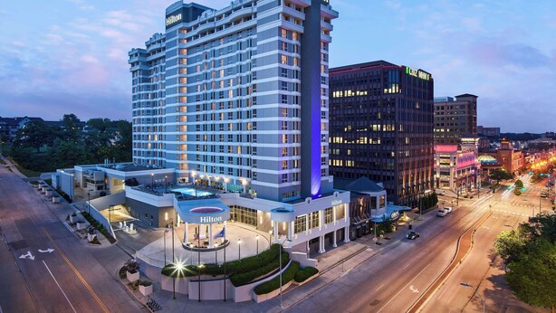 Un hôtel Hilton au design moderne, comprenant plusieurs étages et une entrée imposante.