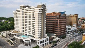 Un grand hôtel Hilton doté d’une piscine sur le toit et d’un bâtiment moderne attenant.