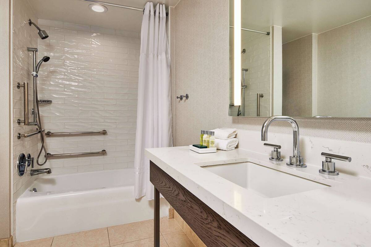 Ein modernes Badezimmer mit Badewanne, Dusche und zwei Waschbecken.