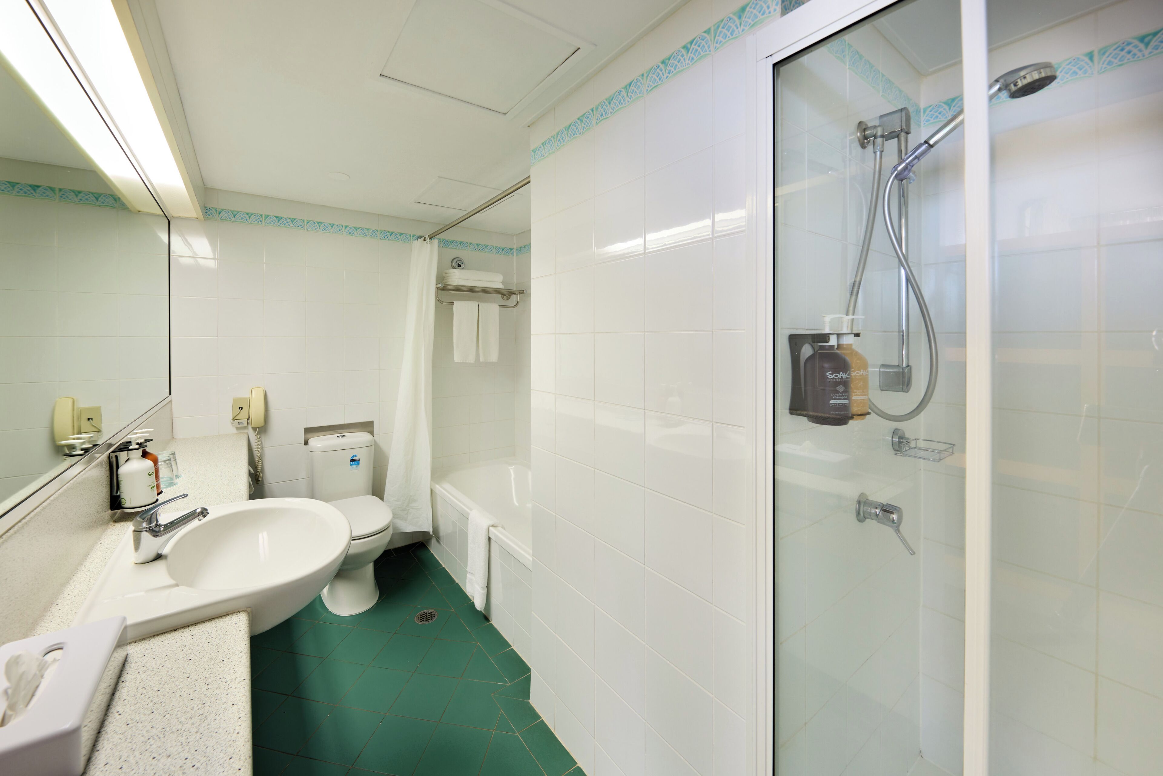 A bathroom with a sink, toilet, and shower.