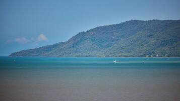 A coastal landscape with a hill and calm sea.