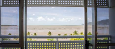 Habitación con vista a la playa a través de una ventana con mosquitero.