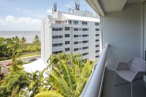 Enjoy the ocean view from this balcony with a wicker chair.