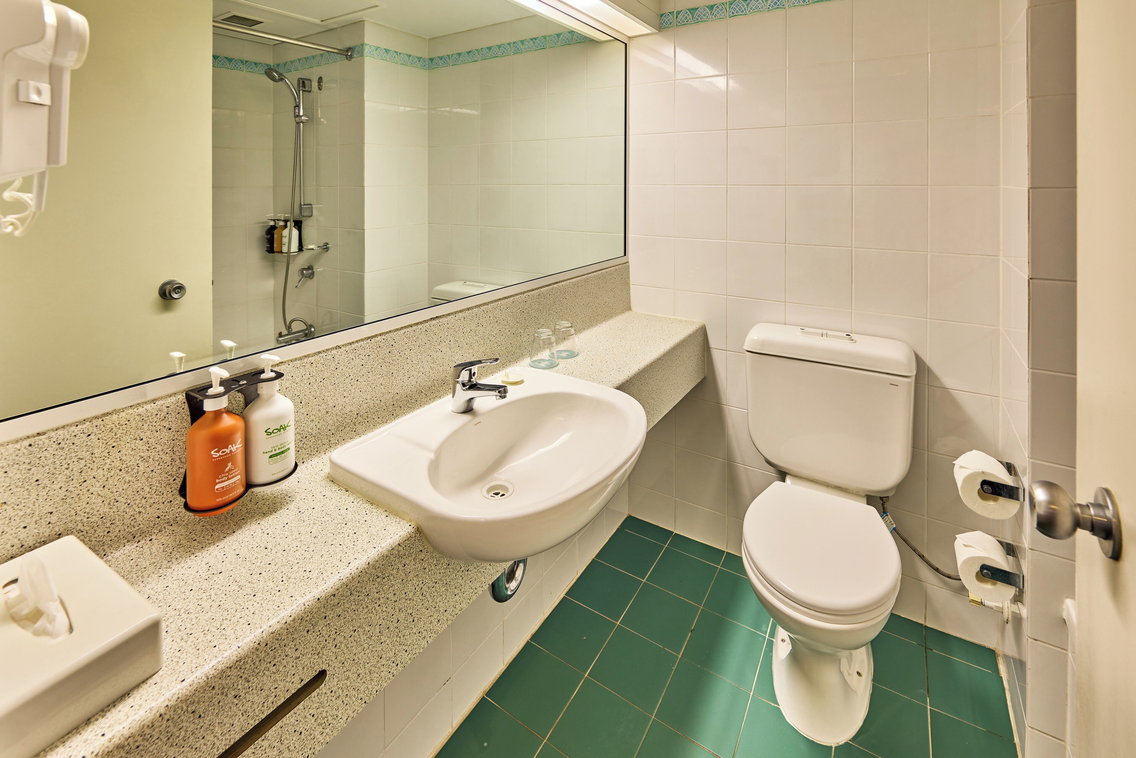 A bathroom with a sink, mirror, and toilet.