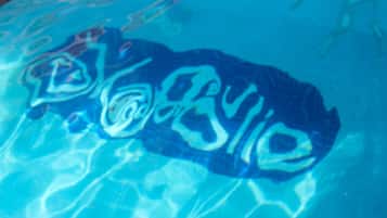 A clear view of a swimming pool with a visible logo on the water's surface.