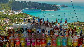 Une vue d’une ville côtière, avec un navire de croisière amarré au port, entouré de nombreuses bouteilles d’alcool.