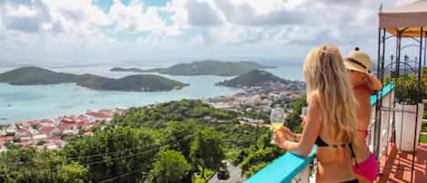 Un balcone con vista su una località costiera e isole.