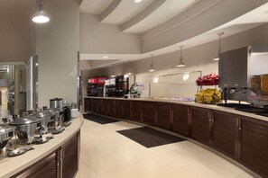 Una cocina moderna con electrodomésticos de acero inoxidable, un montaje tipo bufé y un refrigerador Coca-Cola.