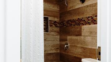 A bathroom with a bathtub, toilet, and shower.