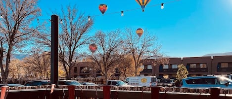 A parking lot with hot air balloons, a wooden fence, and a sign for catering services.