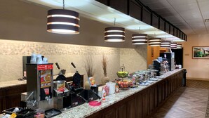 A buffet setup with waffle makers, syrup dispensers, and various food items. - Best Western Crossroads Of The Bluffs (Council Bluffs)