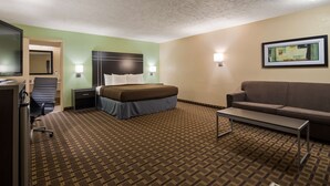 A hotel room with a bed, a sofa, a desk, a chair, and a painting on the wall. - Best Western Coachlight (Rolla)