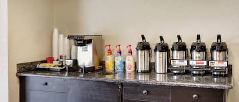 A kitchenette with a coffee machine, coffee dispensers, and a Bunn coffee maker.