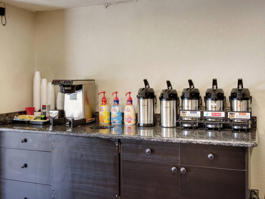 A kitchenette with a coffee machine, coffee dispensers, and a Bunn coffee maker.