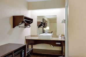 A hotel bathroom with a sink, mirror, towel rack, and a small cabinet. - Red Roof Inn Grand Rapids Airport (Grand Rapids)