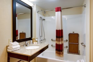 A bathroom with a sink, mirror, shower, and a towel rack. - Red Roof Inn Grand Rapids Airport (Grand Rapids)