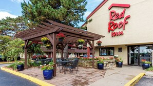 Ein Red Roof Inn mit Außenbestuhlung und Blumenkörben.
