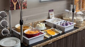 Un buffet proposant une variété de plats et d'ustensiles.