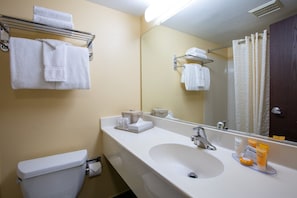 A bathroom with a toilet, sink, mirror, and towel rack. - Budget Inn NAU Downtown Flagstaff (Flagstaff)