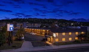 A hotel with a signboard, a parking lot, and a mountain in the background. - Budget Inn NAU Downtown Flagstaff (Flagstaff)