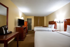 A hotel room with two beds, a desk with a coffee maker, a television, and a door leading to a bathroom. - Budget Inn NAU Downtown Flagstaff (Flagstaff)
