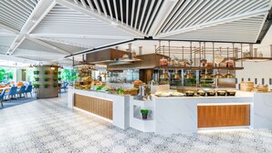 Een modern restaurant met een centraal gelegen toonbank, hangende lampen en een vloer met patroon.