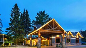 Eine Lodge mit überdachter Veranda, steinernen Säulen und einem Holzdachstuhl.