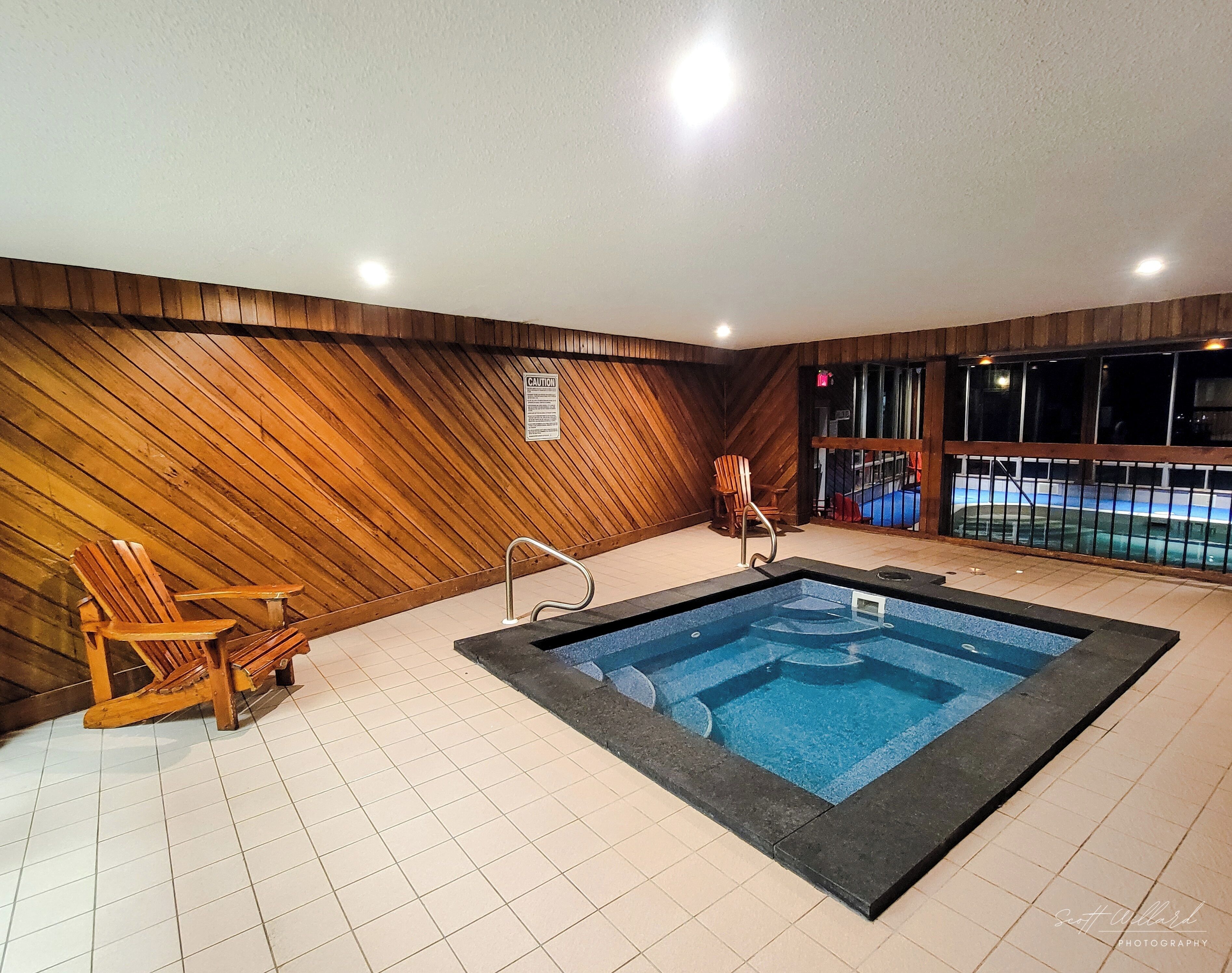 Una piscina interna con pareti in legno e pavimento piastrellato.