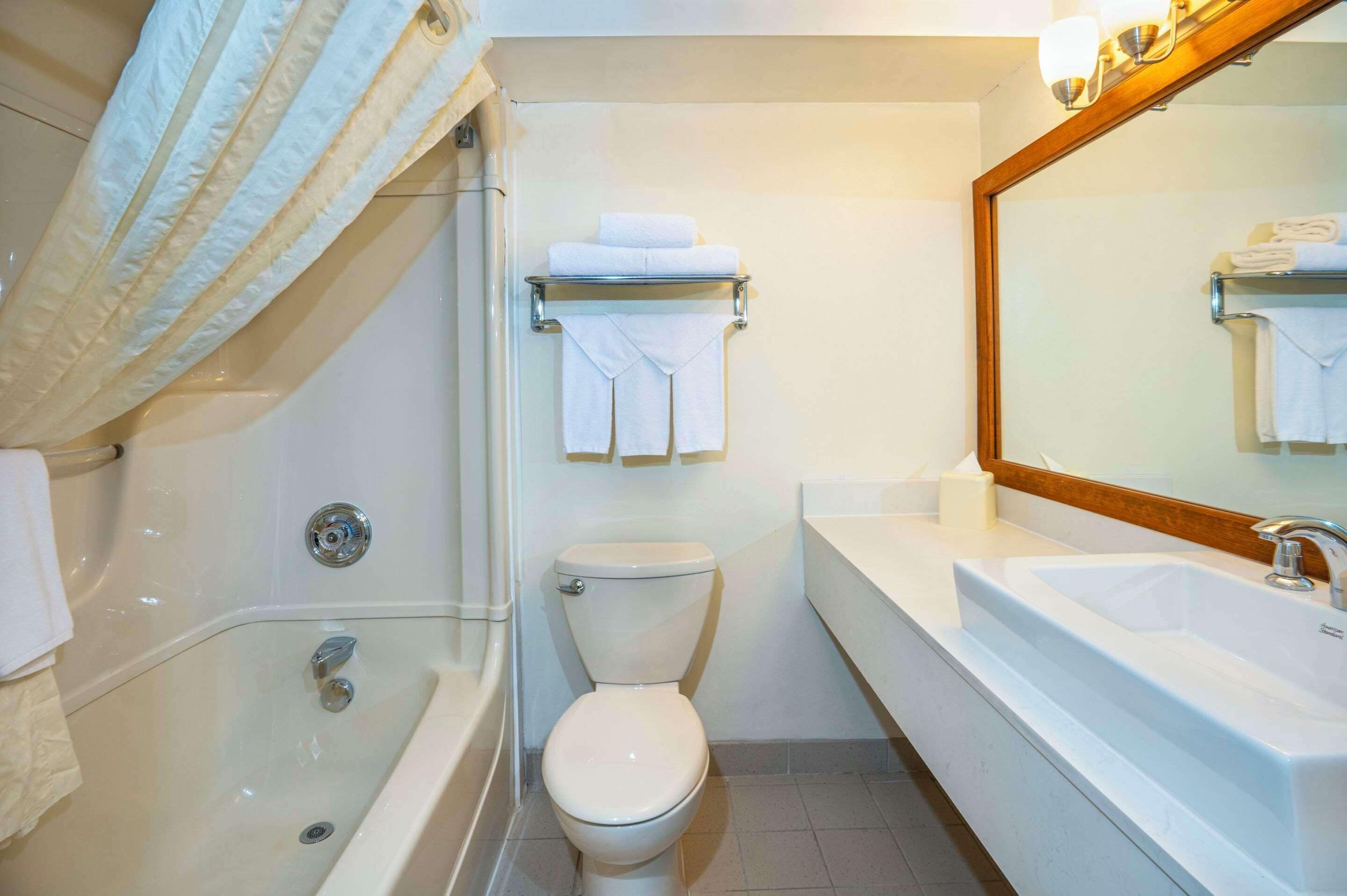 A bathroom with a bathtub, toilet, and sink.