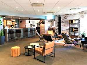 Een moderne lounge met een bar, een open haard en een geaccentueerde bakstenen muur.