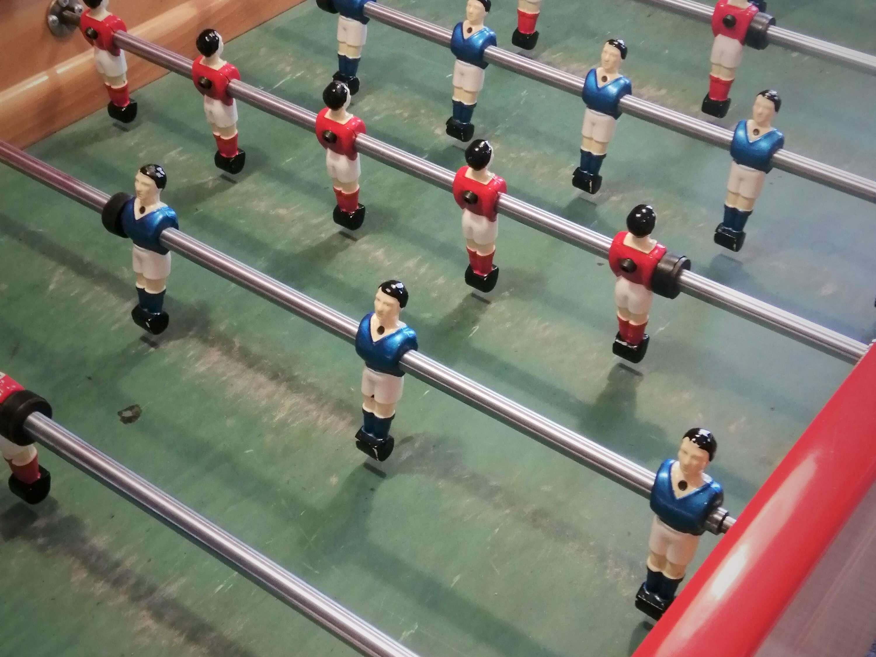 A foosball table with figures in blue and red uniforms.