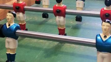 Una mesa de fútbol de mesa con figuras de uniforme azul y rojo.