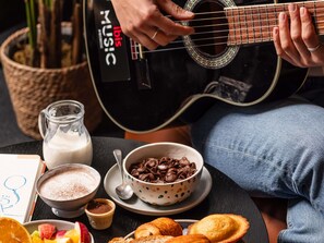 A person playing a guitar, a bowl of chocolate chips, a milk jug, and a drawing on a napkin. - ibis Poitiers Sud (Poitiers)