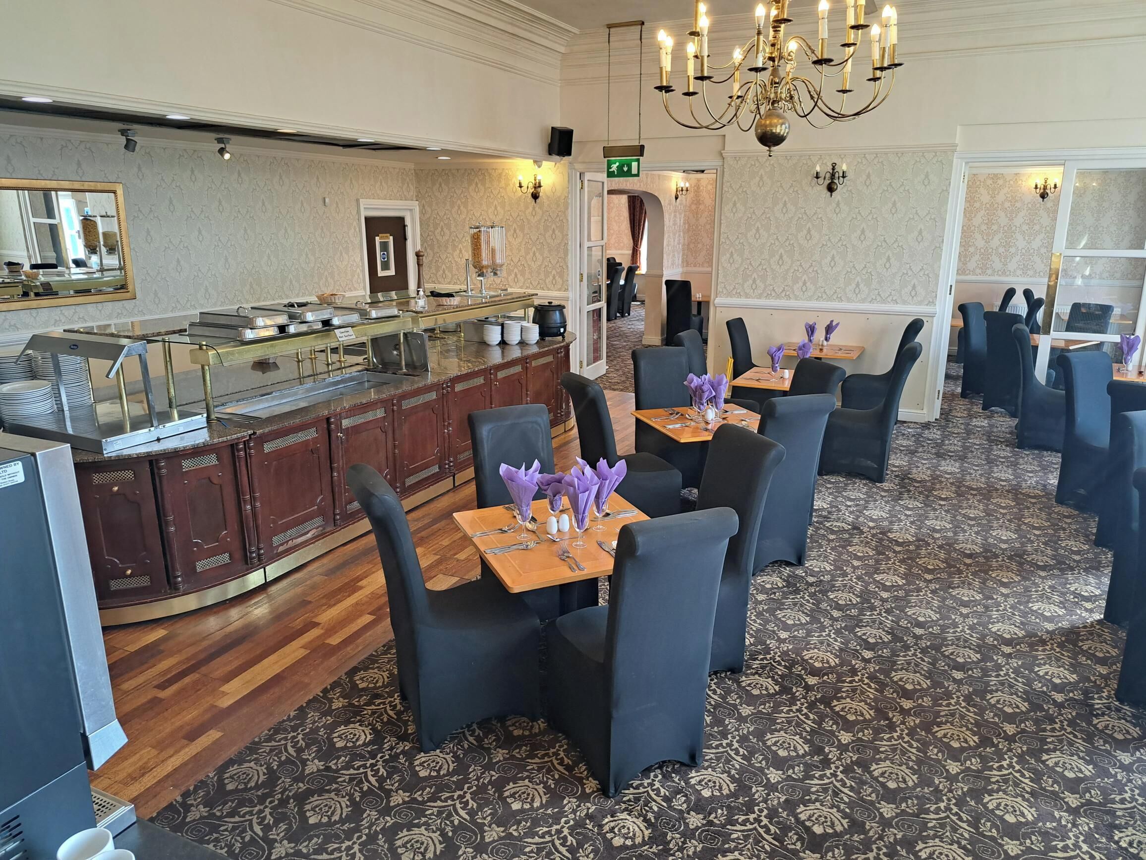 A buffet area with a counter, chairs, and tables set up for dining.