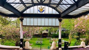 A covered garden area with a gazebo, picnic tables, and a fountain.