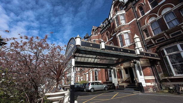 A historic building with a classic architectural style, featuring a prominent entrance with steps and a covered area.