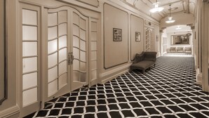 A hallway with a black and white patterned floor, a sofa, and a sign indicating the International Suite.