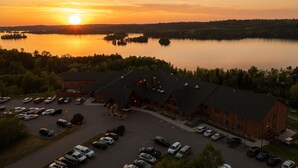 A lodge with a large parking lot and a view of a lake at sunset. - Grand Ely Lodge Resort & Conference Center (Ely)